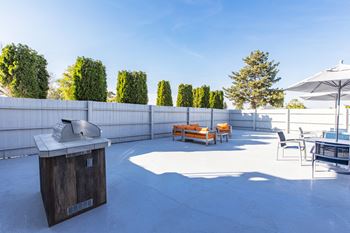 The terrace has a grill and seating area with tables and chairs